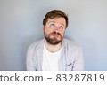 Tired bearded man in a shirt looks with his eyes upward with suffering and supplication. Gray 83287819