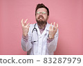 Doctor with a stethoscope around neck in stress, he bares teeth furiously and makes a gesture with 83287979