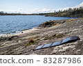 Portable solar panels lie on the stone shore of the lake and accumulate energy. Modern technologies 83287986