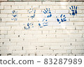 Brick white wall with blue handprints. Copy space. Great idea. Abstract background. 83287989