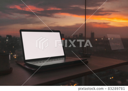 Laptop on the desk at the balcony with evening sunset city view. Laptop on the desk at the balcony with evening sunset city view. 83289781