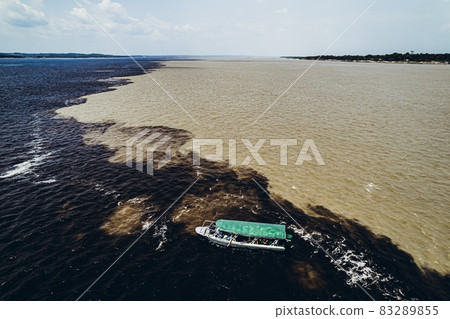 Boat with tourists on the verge of mixing rivers. Amazon. Boat with tourists on the verge of mixing rivers. Amazon. 83289855