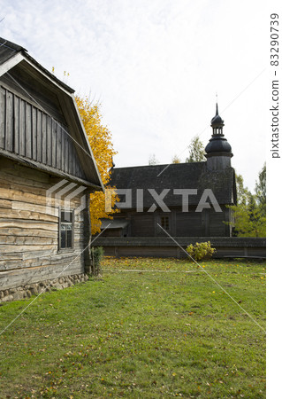 An old rustic wooden hut. In the background there is a rustic wooden church. An old rustic wooden hut. In the background there is a rustic wooden church. 83290739