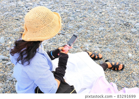 一位女士在海灘旅行時使用手機 一位女士在海灘旅行時使用手機 83291699