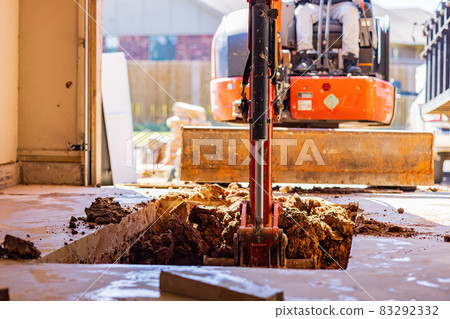 Worker was working on a garage underground storm shelter installation Worker was working on a garage underground storm shelter installation 83292332