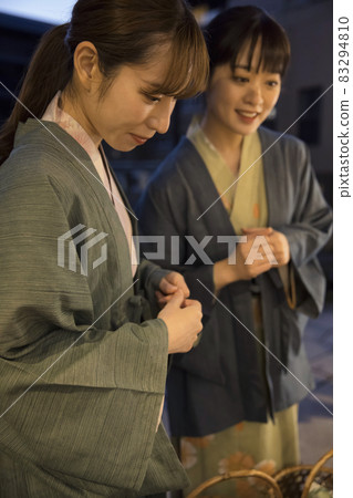 A young woman looking into a souvenir shop in a hot spring town at night A young woman looking into a souvenir shop in a hot spring town at night 83294810