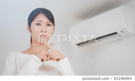 Image of a woman doing a batten air conditioner 83296064