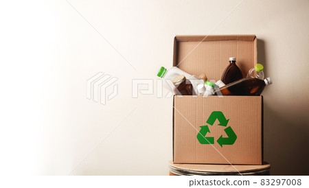 Climate and Environmentally Conservation Concept. Recycling Corrugated Box with Full of Plastic and Glass Bottle againts the Green Wall. Zero Waste, Reduce Plastic. Environment, Ecology Care and Climate and Environmentally Conservation Concept. Recycling Corrugated Box with Full of Plastic and Glass Bottle againts the Green Wall. Zero Waste, Reduce Plastic. Environment, Ecology Care and 83297008