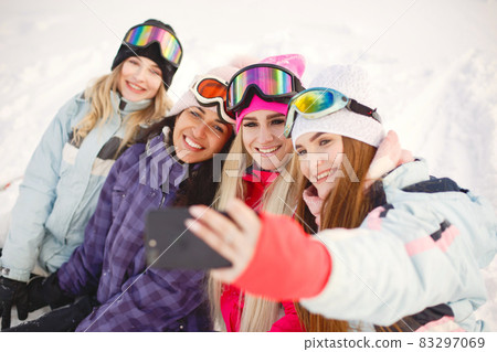 Group of girls taking selfies in mountains on skis 83297069