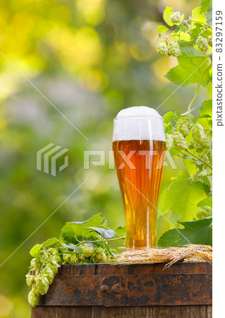 glass of beer with wheat ears and hop cones 83297159