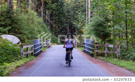 Adventurous Woman Bike Riding on a Trail in Forest 83297633