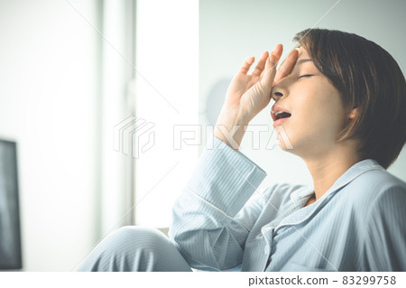 A woman with a tired, sleep-deprived expression. A woman with a tired, sleep-deprived expression. 83299758