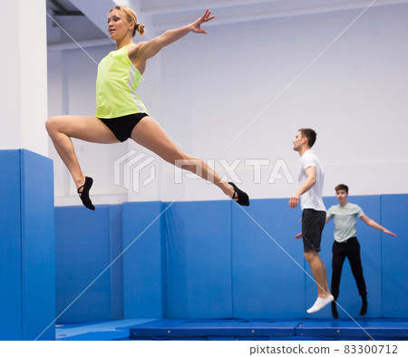 Woman exercising on trampoline Woman exercising on trampoline 83300712