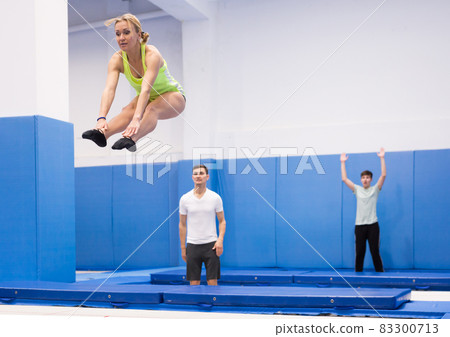 Female gymnast exercising L shape on trampoline Female gymnast exercising L shape on trampoline 83300713