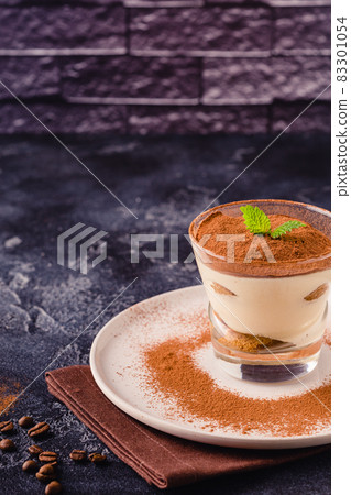 Traditional Italian dessert tiramisu in a glass. Traditional Italian dessert tiramisu in a glass. 83301054