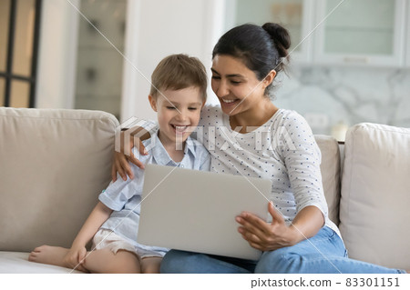 Happy mixed race family using computer at home. 83301151