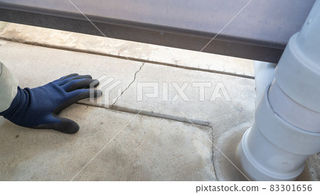 Workers inspecting cracks in concrete floors. 83301656