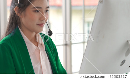 Businesswoman wearing headset working actively in office 83303217