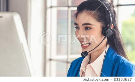 Businesswoman wearing headset working actively in office 83303657
