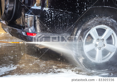 Car washing. Cleaning car with high pressure water and foam Car washing. Cleaning car with high pressure water and foam 83305556