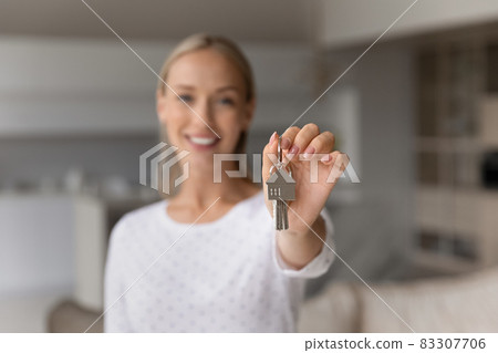 Close up smiling young woman holding keys in hands. Close up smiling young woman holding keys in hands. 83307706