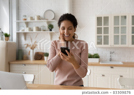 Excited woman triumph with good news on cellphone 83309876