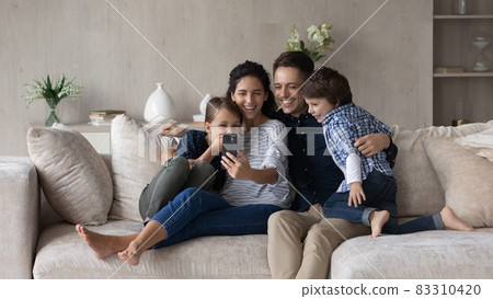 Happy friendly family with kids using cellphone. 83310420