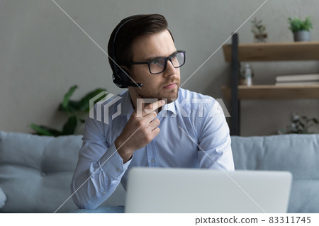 Close up confident thoughtful businessman in headphones looking in distance 83311745