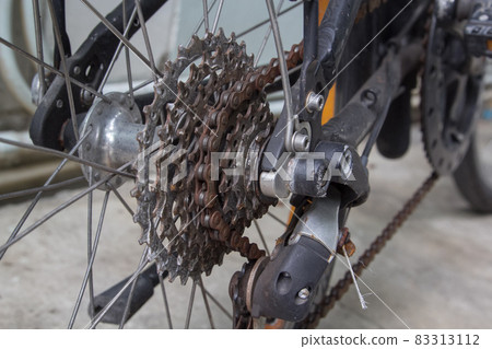 Close up of dirty bicycle rear gear and rusty chain Close up of dirty bicycle rear gear and rusty chain 83313112