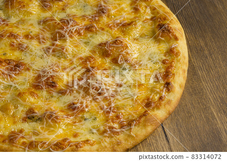 Baked pizza with cheese on a wooden background Baked pizza with cheese on a wooden background 83314072