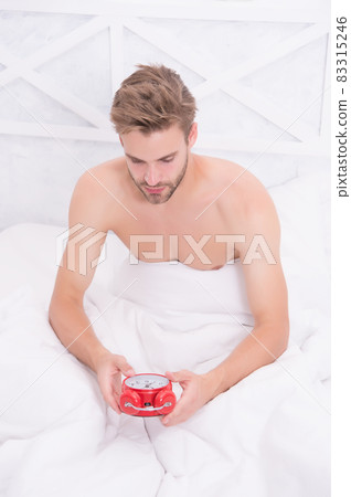 Man waking up early morning ringing alarm clock, set up clock concept Man waking up early morning ringing alarm clock, set up clock concept 83315246