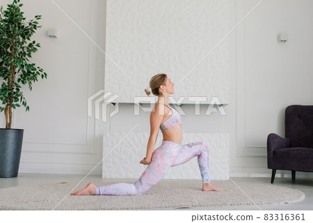 View of beautiful young woman working out in luxury fitness center, doing yoga or pilates exercise. View of beautiful young woman working out in luxury fitness center, doing yoga or pilates exercise. 83316361