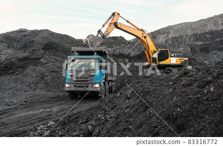 Large quarry dump truck. Loading the rock in dumper. Loading coal into body truck. Production useful minerals. Mining truck mining machinery, to transport coal from open-pit as the Coal Production Large quarry dump truck. Loading the rock in dumper. Loading coal into body truck. Production useful minerals. Mining truck mining machinery, to transport coal from open-pit as the Coal Production 83316772