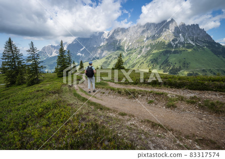 Traveler man on hiking trail enjoying Wilder Kaiser mountains, Tirol - Austria Traveler man on hiking trail enjoying Wilder Kaiser mountains, Tirol - Austria 83317574