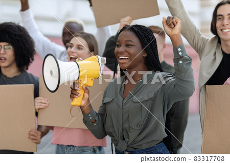 Excited african american woman with loudspeaker over crowd Excited african american woman with loudspeaker over crowd 83317708