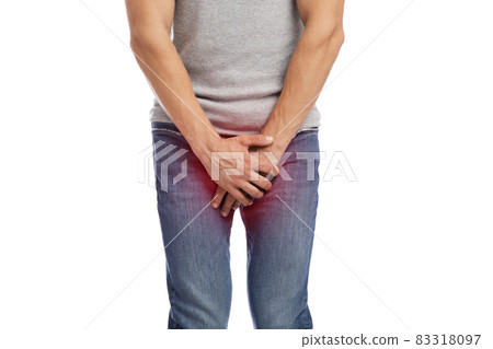 Unrecognizable young european guy suffer from crotch pain, presses hands, highlighted in red Unrecognizable young european guy suffer from crotch pain, presses hands, highlighted in red 83318097