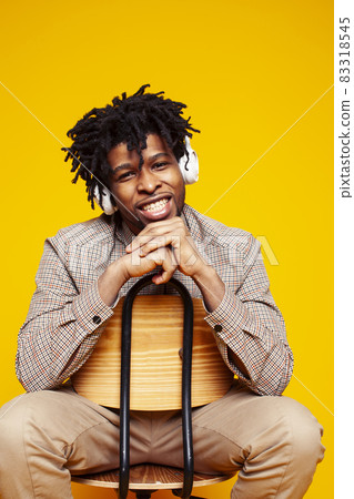 young handsome african american guy student posing cheerful and gesturing on yellow background, lifestyle people concept 83318545