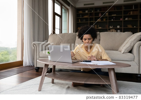 Focused young african american woman managing household budget. Focused young african american woman managing household budget. 83319477