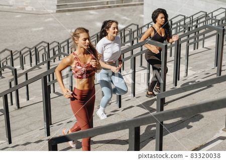 Three athletic women running upstairs at urban city stadium. Three athletic women running upstairs at urban city stadium. 83320038