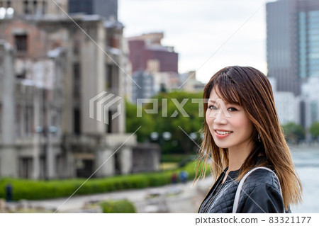 A smiling woman against the backdrop of the Atomic Bomb Dome A smiling woman against the backdrop of the Atomic Bomb Dome 83321177