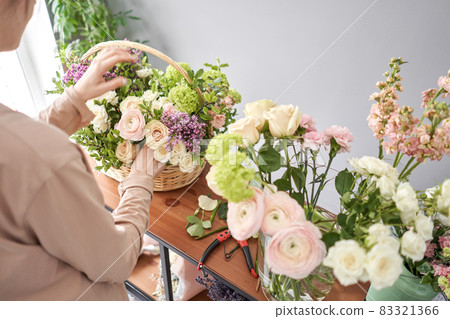 Woman florist creating beautiful bouquet in flower shop. Work in flower shop. Flowers delivery. Woman florist creating beautiful bouquet in flower shop. Work in flower shop. Flowers delivery. 83321366