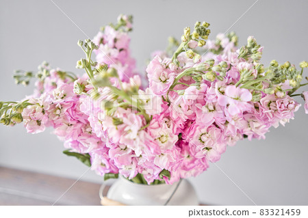 Bouquet of Beautiful lilac mattiola. Spring flowers in vase on wooden table. Flowers delivery. 83321459