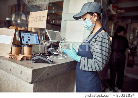 Female cafe worker checking online orders indoors Female cafe worker checking online orders indoors 83321854