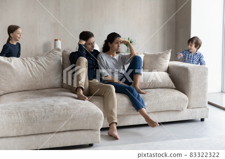 Stressed frustrated young parents feeling exhausted of noisy kids. Stressed frustrated young parents feeling exhausted of noisy kids. 83322322