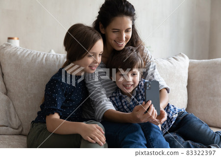 Happy family using cellphone on weekend at home. 83322397