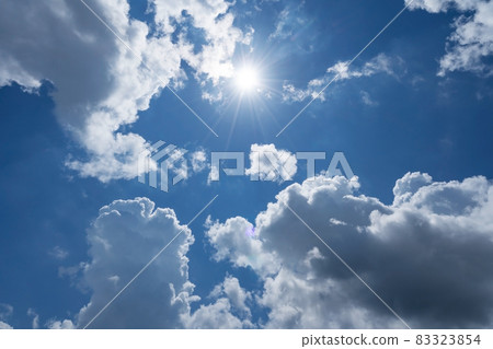 Shining sun on clear blue sky with lens flare of sunlight on sky background Bright sun on blue sky white clouds Nature and environment background 83323854