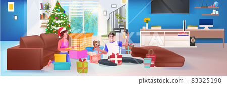 couple unpacking wrapped gifts near decorated fir tree happy new year and merry christmas holidays celebration couple unpacking wrapped gifts near decorated fir tree happy new year and merry christmas holidays celebration 83325190