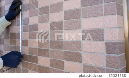 A worker who measures the dimensions of the outer wall. Cracks in joints. 83325388