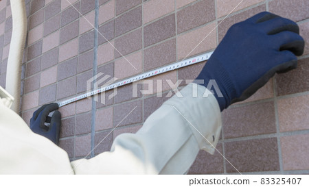 A worker who measures the dimensions of the outer wall. 83325407