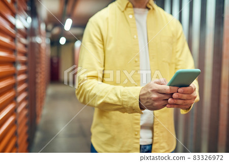 Man without face with smartphone in hands 83326972